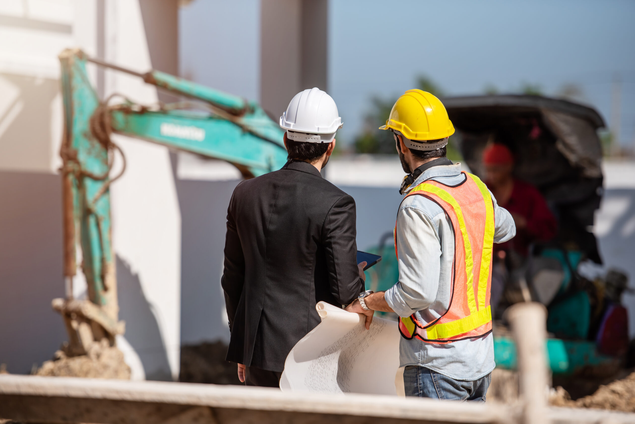 Construction worker and engineer working together on construction site.